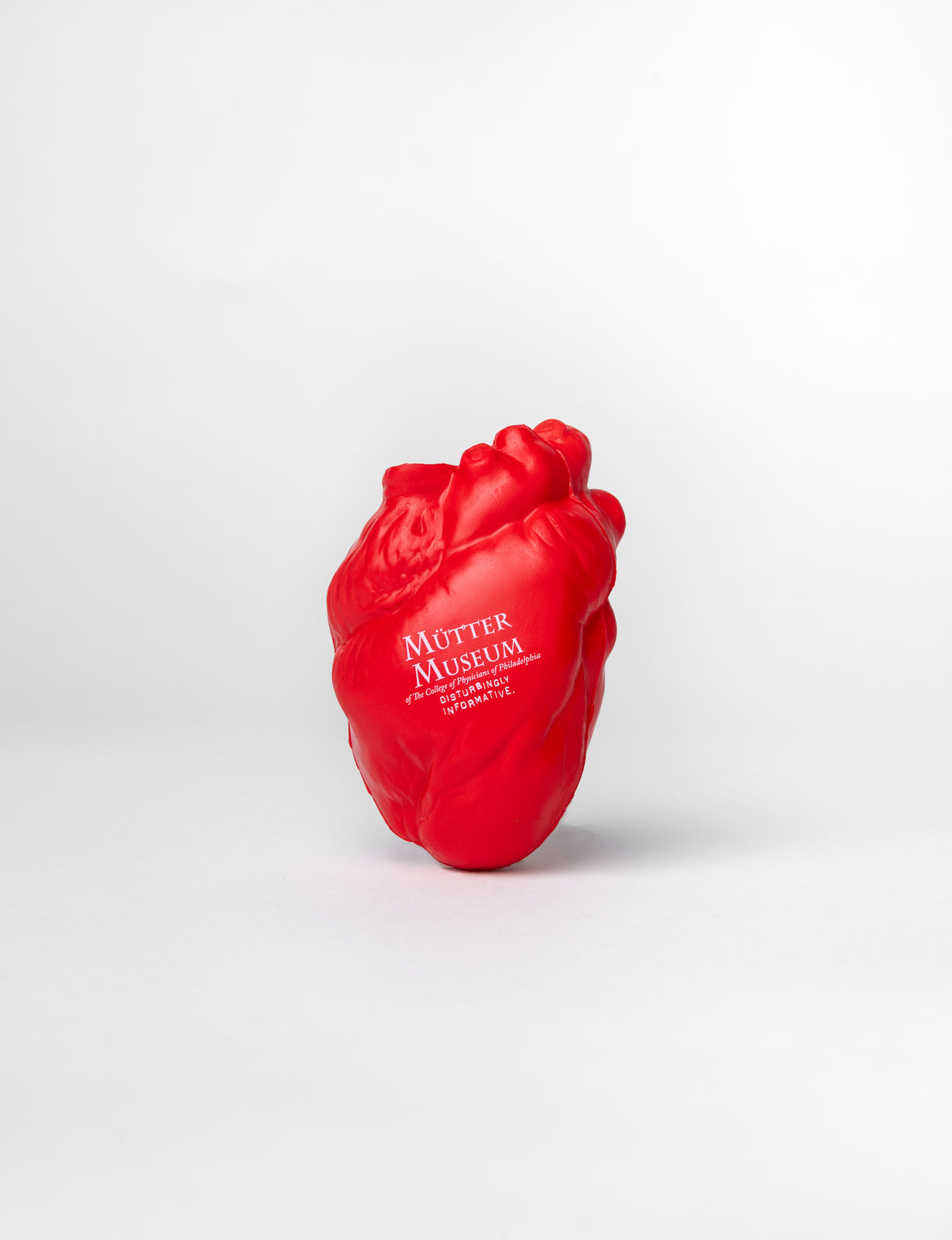 A red foam squeeze toy in the shape of a heart with the Mütter Museum logo in white imprinted on it.