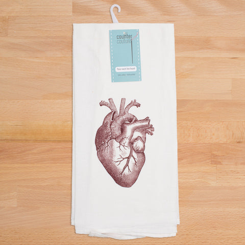 Singular red anatomical heart on white tea towel.