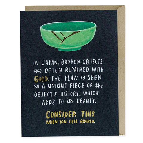 A navy greeting card with a picture of a cracked green bowl with gold filling in the crack. The text reads "In Japan, broken objects are often repaired with gold. The flaw is seen as a unique piece of the object's history, which adds to its beauty. Consider this when you feel broken."
