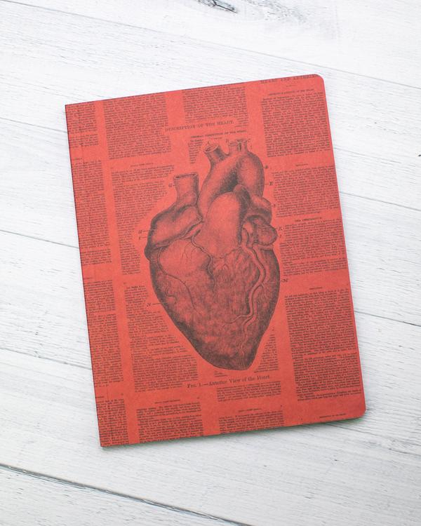 A red notebook with an illustration of a heart in the center and text surrounding it.