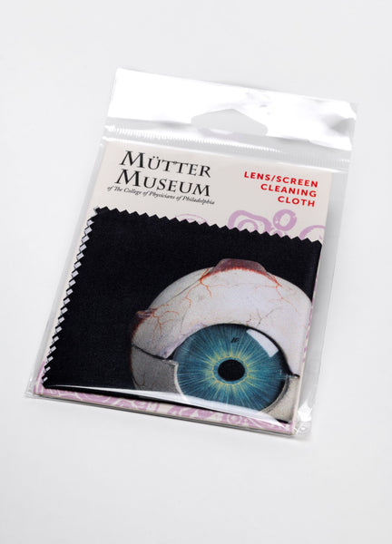 A package that reads "Lens/Screen Cleaning Cloth" with the Mütter Museum logo on it. Inside is a black cloth with a photo of the papier-mache eyeball model.