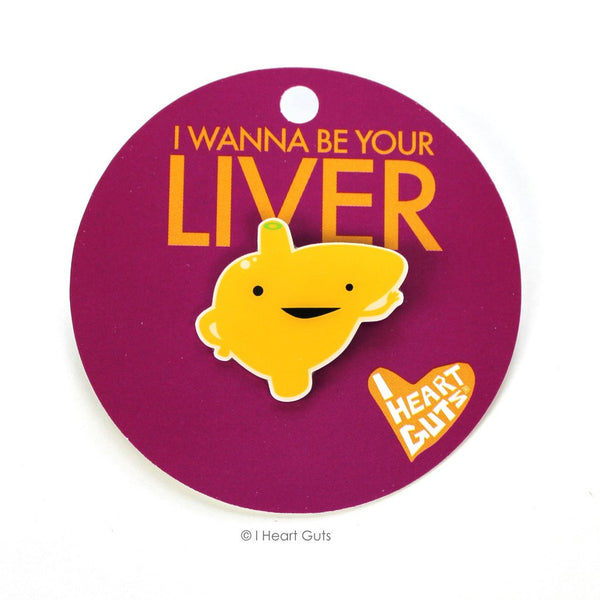 A maroon card with "I Wanna Be Your Liver" in yellow letters written on it. There is a yellow enamel pin in the shape of a liver with two eyes and a smile on it.