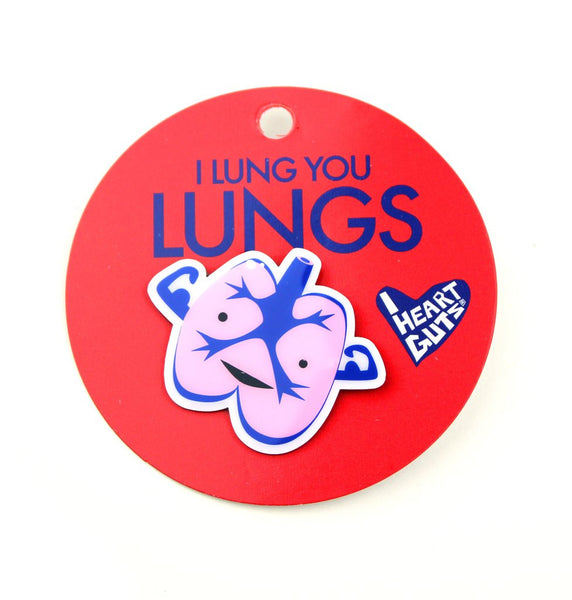 A red card with "I Lung You Lungs" written on it in blue letters. There is a pink and blue enamel pin in the shape of lungs with two arms depicting muscles. There are two eyes and a smile.