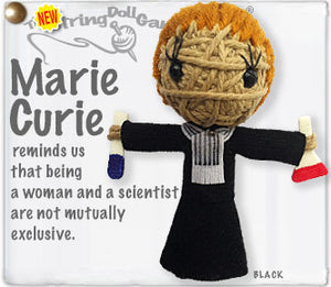 A string doll depicting Marie Curie, with orange hair pulled back into a bun. She is wearing a black dress with white ascot and is holding two beakers with red and blue liquid.